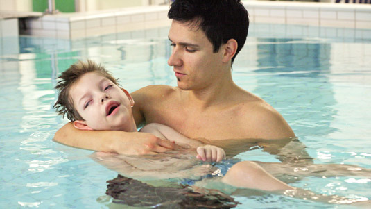 kinderintensivpflege kind mit pfleger im Wasser